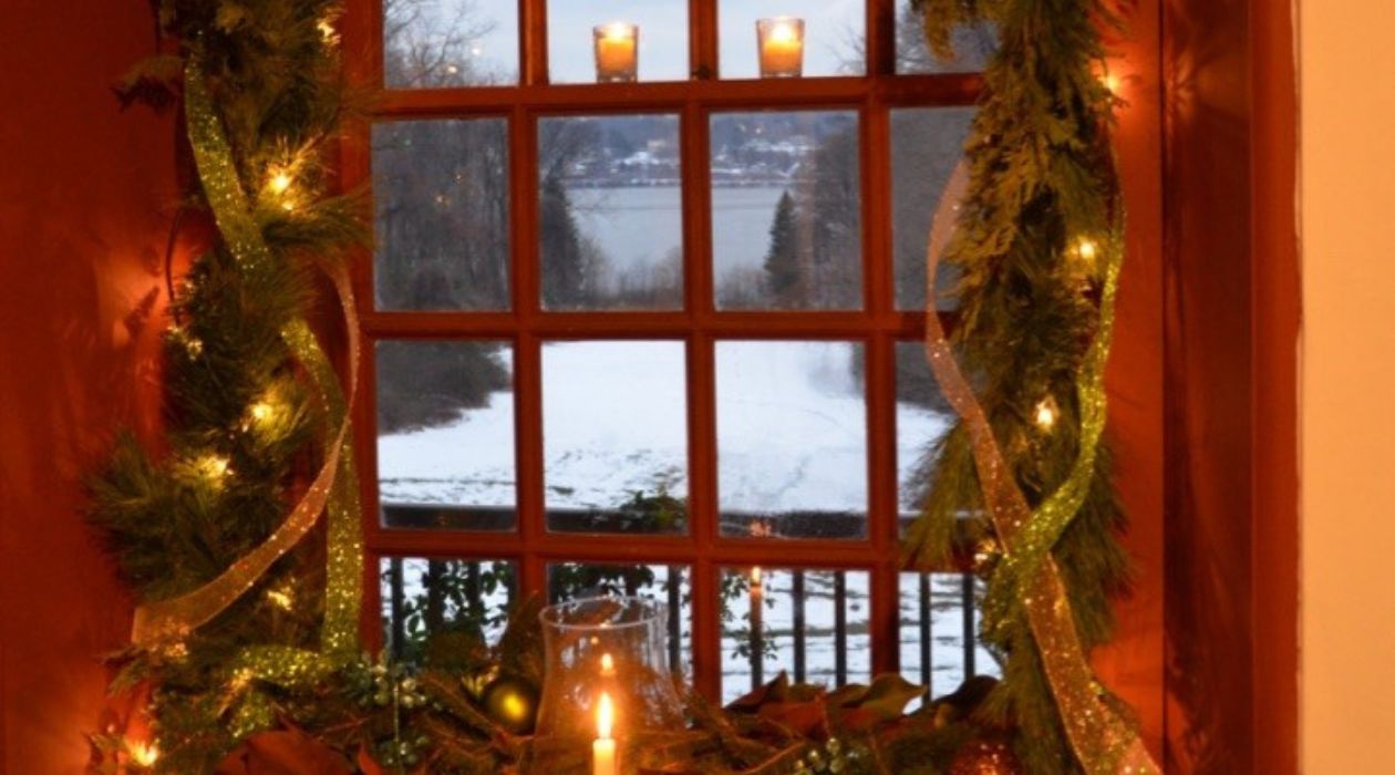 The view looking out an ornately decorated window at the snow covered embankment that leads down to the Hudson River at Mount Gulian Historic Site in Beacon